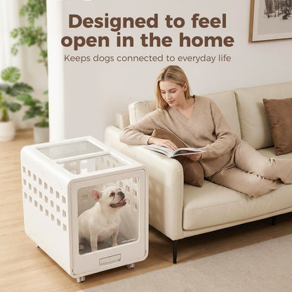Woman reading a book on a couch next to a white pet crate with a dog inside, in a home setting.